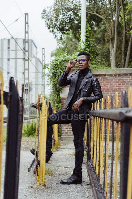 Uomo nero appoggiato sulla recinzione — Foto stock