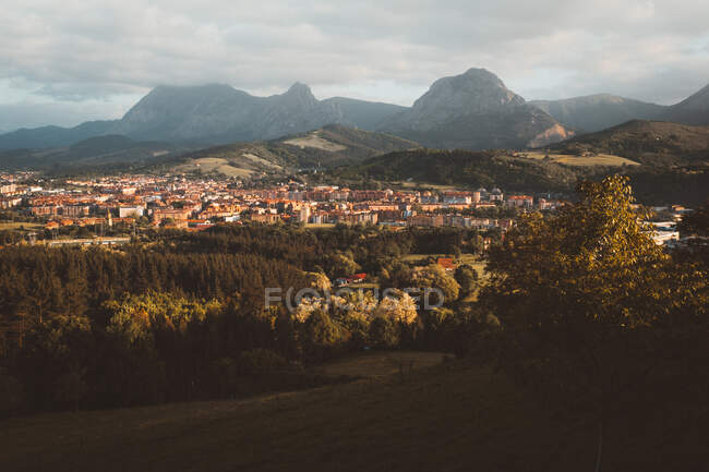Erstaunliche Landschaft der Stadt auf einem Gelände mit grünen Wäldern und Bergen im Hintergrund, Bizkaia — Stockfoto