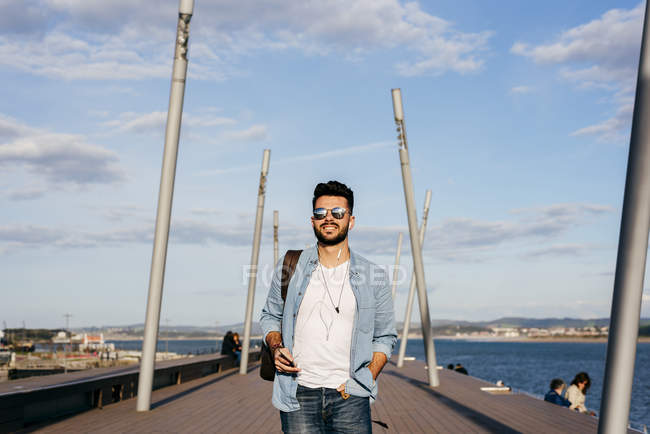 Man with backpack strolling on waterfront — Stock Photo