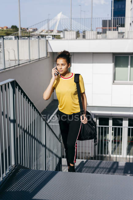 Спортивная женщина разговаривает на смартфоне — стоковое фото