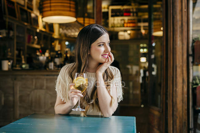 Mujer con bebida sentado en la cafetería - foto de stock