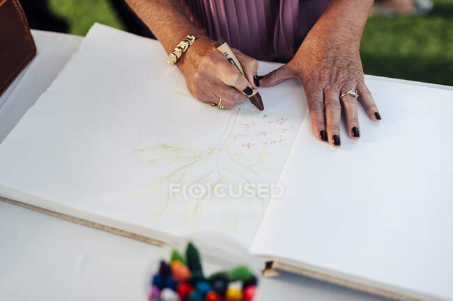 Hands of unrecognizable person writing greetings in the book. - foto de stock