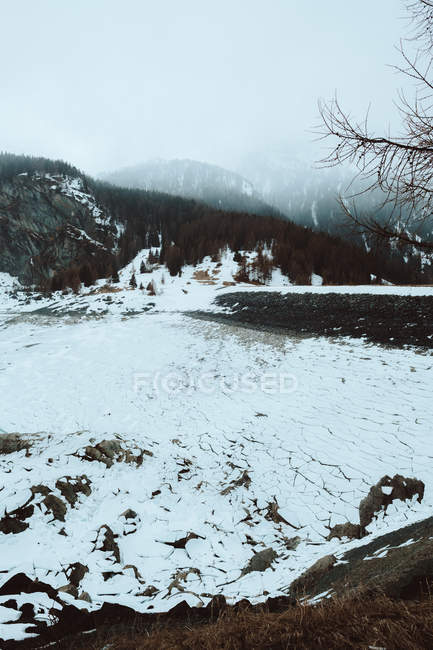 Lago congelado en montañas nevadas - foto de stock