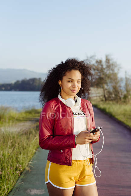 Mulher afro-americana com smartphone no campo — Fotografia de Stock