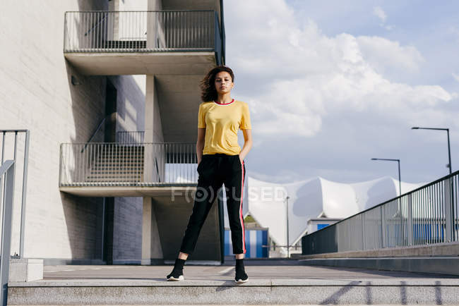 Mulher desportiva em pé na frente do edifício — Fotografia de Stock