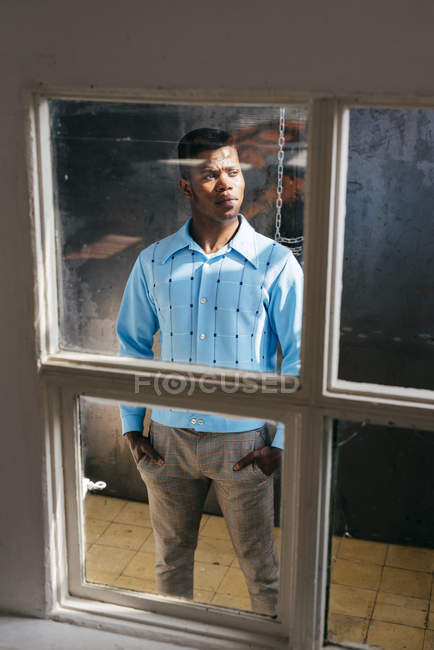 Preto homem olhando para fora sujo janela — Fotografia de Stock