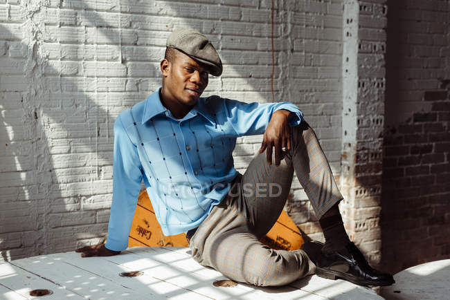 Elegante homem preto sentado no chão — Fotografia de Stock