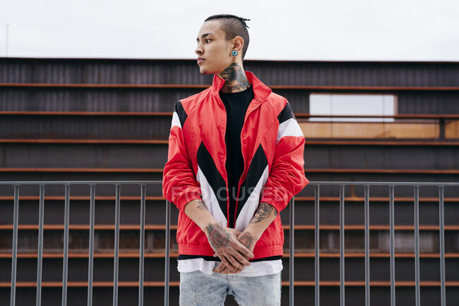 Молодий чоловік з татуюваннями, що стоять на вулиці — стокове фото