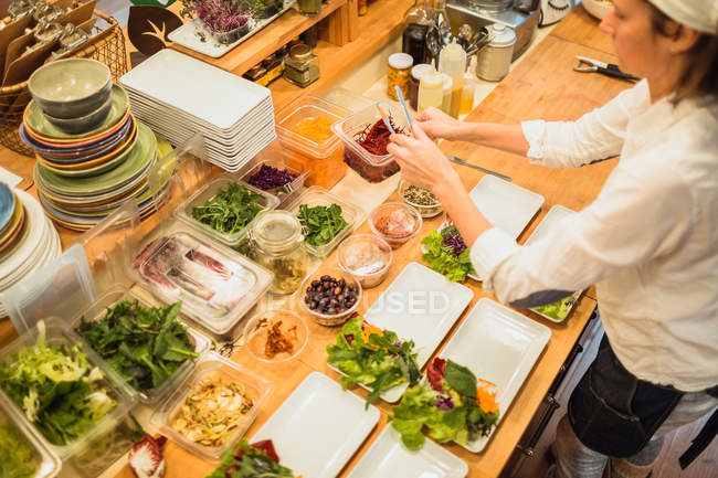 Mulher servindo pratos com salada — Fotografia de Stock