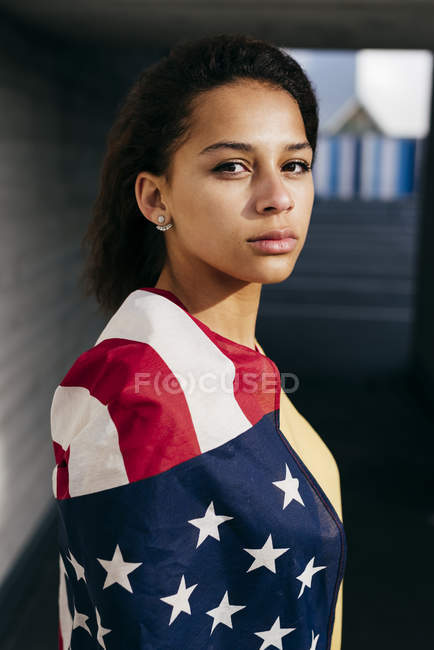 Femme enveloppée dans le drapeau des États-Unis — Photo de stock
