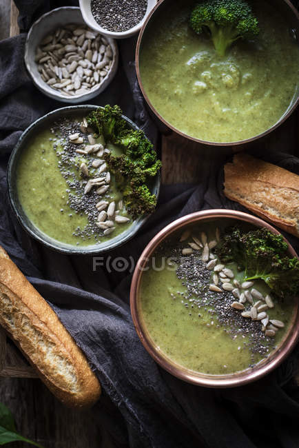 Bols de soupe verte avec brocoli sur table rustique en bois — Photo de stock