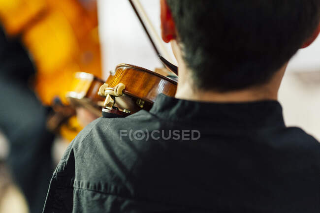 Зворотній перегляд невпізнаваного музиканта, що стоїть і грає на скрипці . — стокове фото
