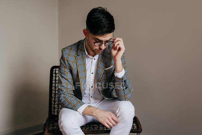 Joven con estilo sentado en la silla - foto de stock