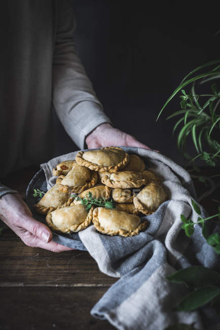 Hands holding golden pies — Stock Photo