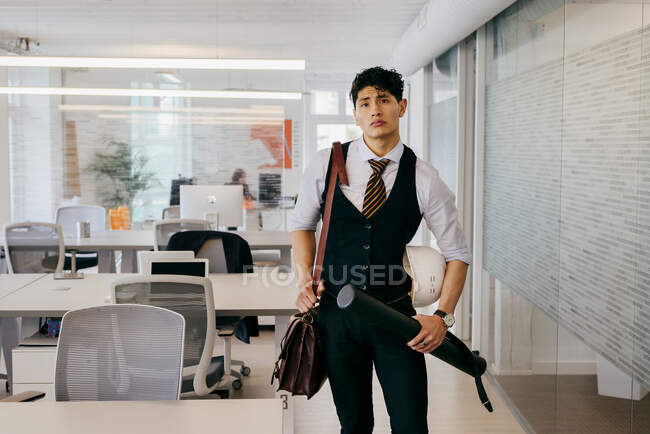 Jeune homme avec un plan dans le bureau — Photo de stock