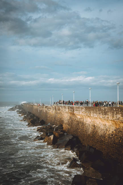 Frente al mar de ladrillo con los turistas - foto de stock