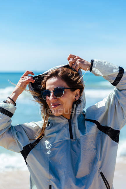 Mulher de óculos em pé na praia — Fotografia de Stock