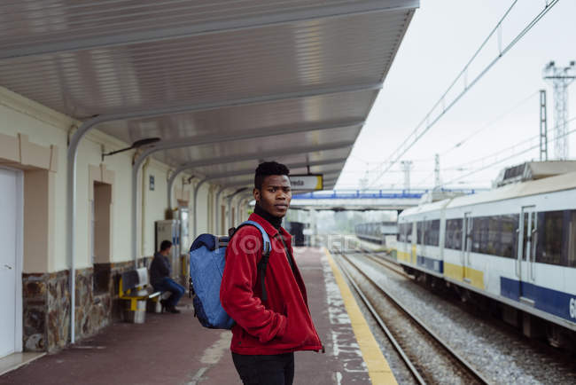 Uomo in piedi sulla stazione ferroviaria — Foto stock