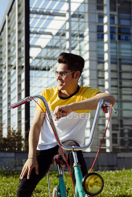 Jeune homme assis sur un vélo vintage — Photo de stock