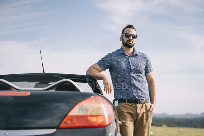 Uomo attraente in posa in auto convertibile. — Foto stock
