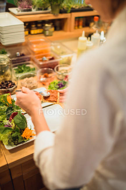 Woman serving plates with vegan snacks — Stock Photo