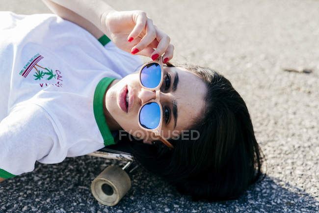 Teenage girl lying on longboard — Stock Photo
