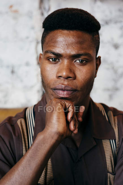 Hombre negro con la mano en la barbilla - foto de stock