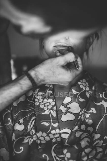 Preto e branco tiro de visto gist homem colocando maquiagem no irreconhecível mulher. — Fotografia de Stock