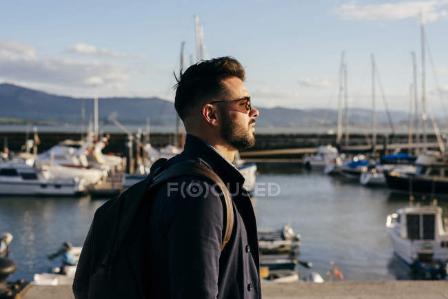 Guy walking in front of sea port — Stock Photo