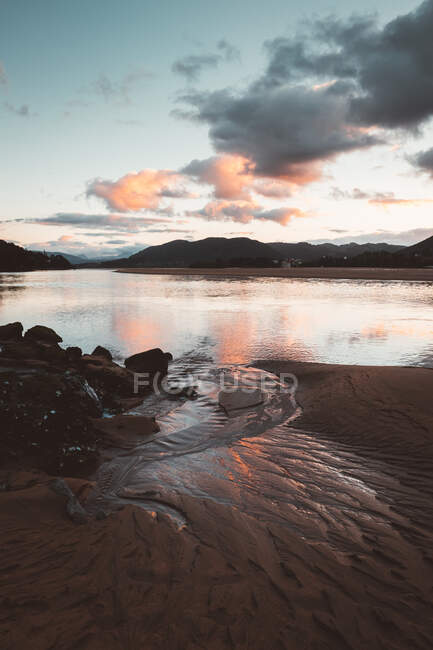 Rocks in water of sea in sunset - foto de stock