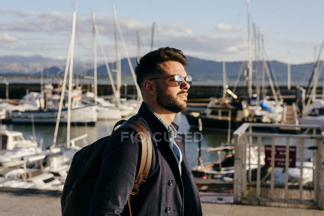 Guy walking in front of sea port — Stock Photo