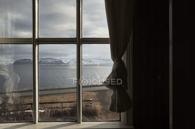У похмурий день в Ісландії мальовничий краєвид на береги озера та сніжні гори. — стокове фото