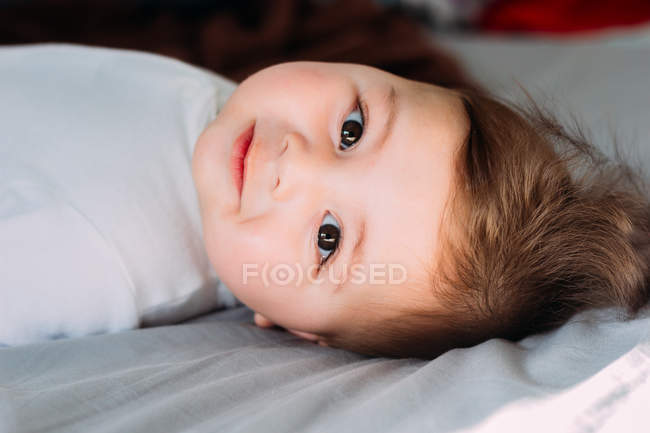 Bambino sdraiato sul letto — Foto stock