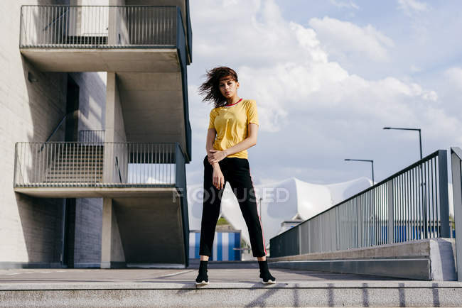 Спортивна жінка стоїть перед будівлею — стокове фото