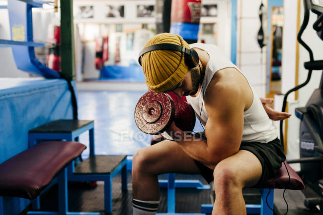 Hombre haciendo ejercicio con la mancuerna en el gimnasio - foto de stock