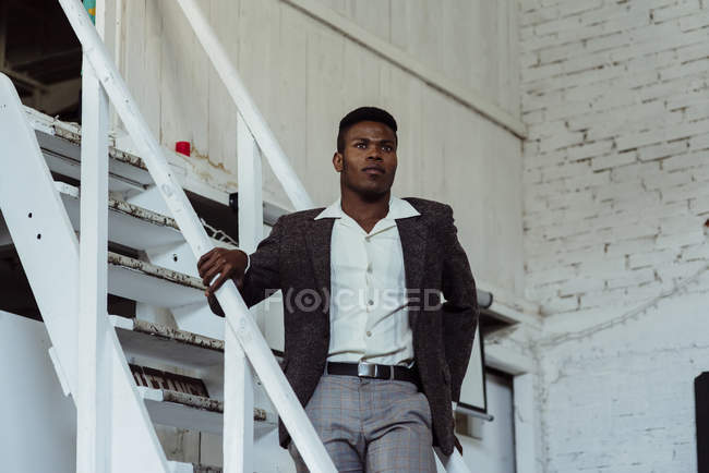 Hombre negro de pie en la escalera - foto de stock