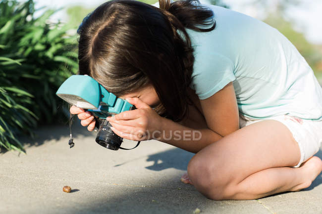Girl shooting snail — Stock Photo