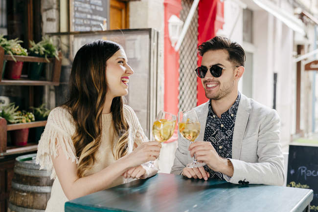 Pareja sentada en la cafetería exterior - foto de stock