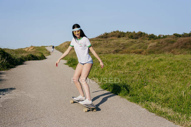Adolescente chica montando monopatín - foto de stock