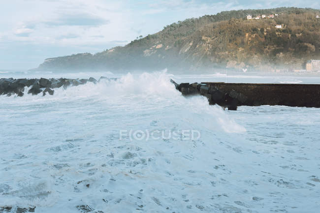 Las tormentosas olas se estrellan contra el rompeolas - foto de stock