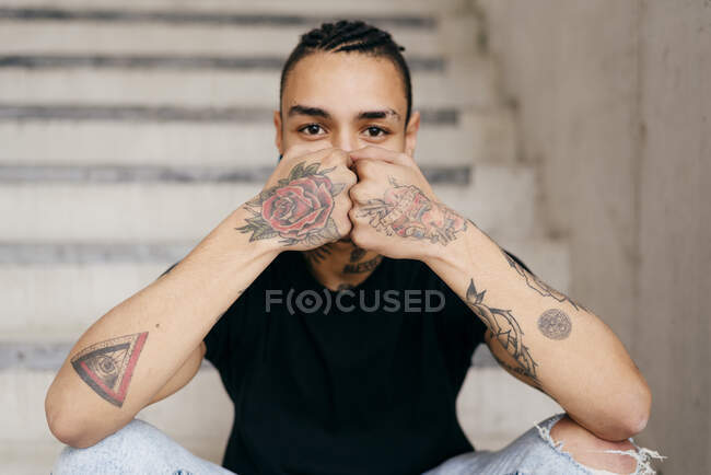 Hipster cobrindo rosto com as mãos tatuadas — Fotografia de Stock