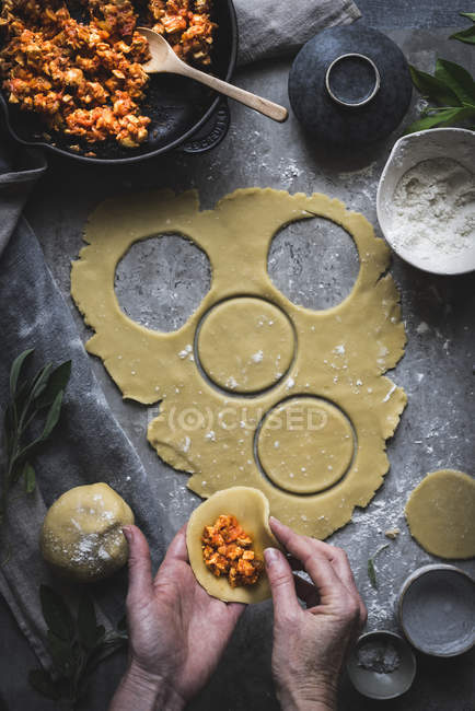 Hands making stuffed pies — Stock Photo