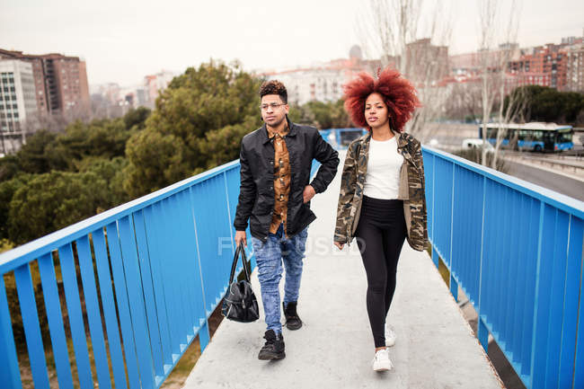 Elegante pareja caminando en el puente - foto de stock