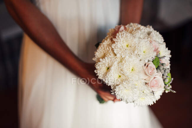 Crop unrecognizable bride with beautiful bunch of pink and white flowers. — Stock Photo