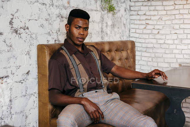 Nero uomo seduto in caffè — Foto stock