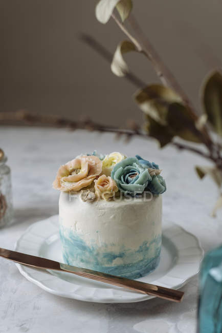Bolo de casamento com flores de creme de manteiga azul e bege na placa branca — Fotografia de Stock