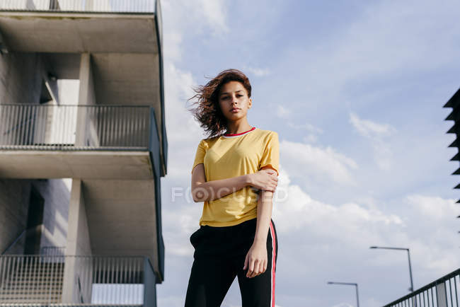 Спортивная женщина стоит перед зданием — стоковое фото