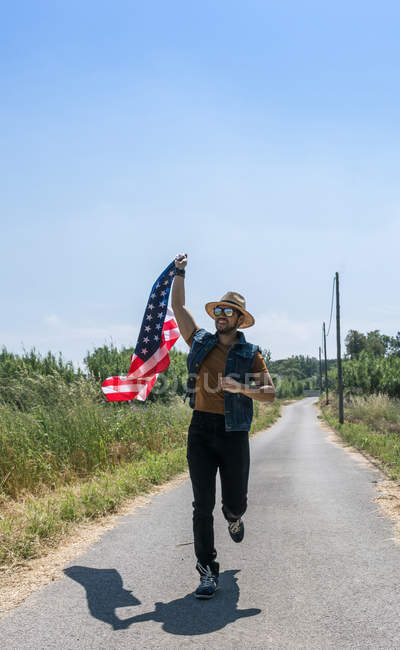 Man running with American flag — Stock Photo