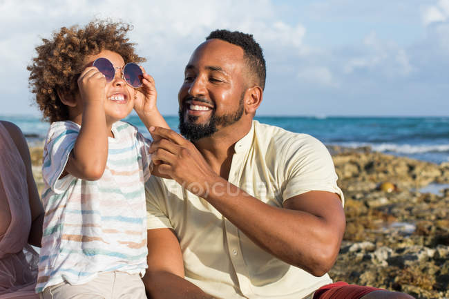 Padre e hijo jugando con gafas de sol - foto de stock
