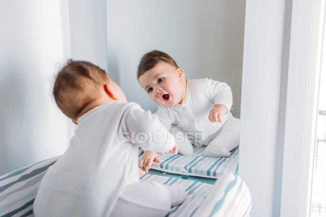 Bébé ludique regardant miroir — Photo de stock